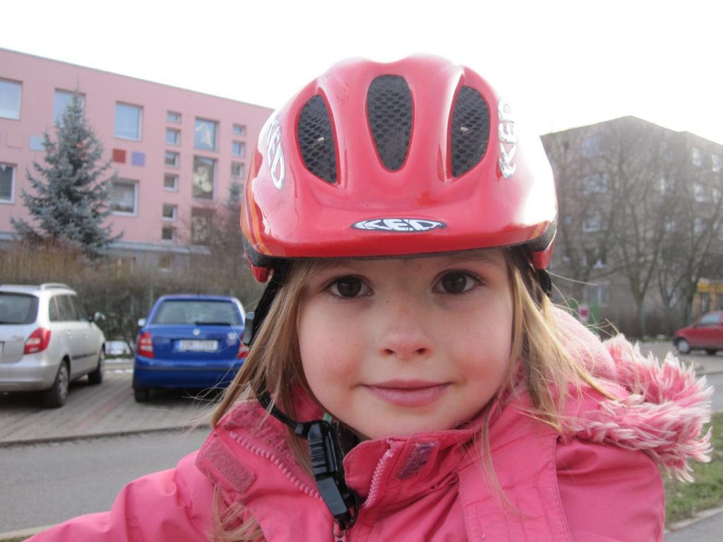 A little girl in a pink bike helmet
