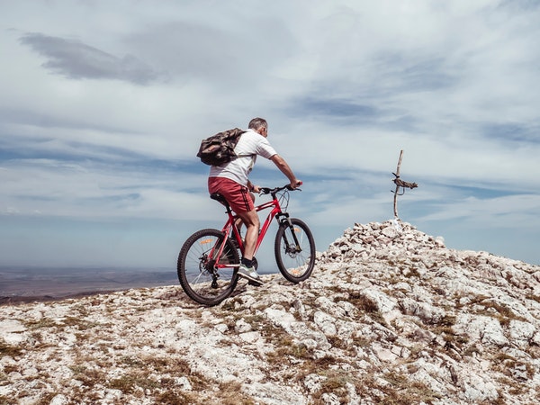 man riding on top of mountain with mountain bike
